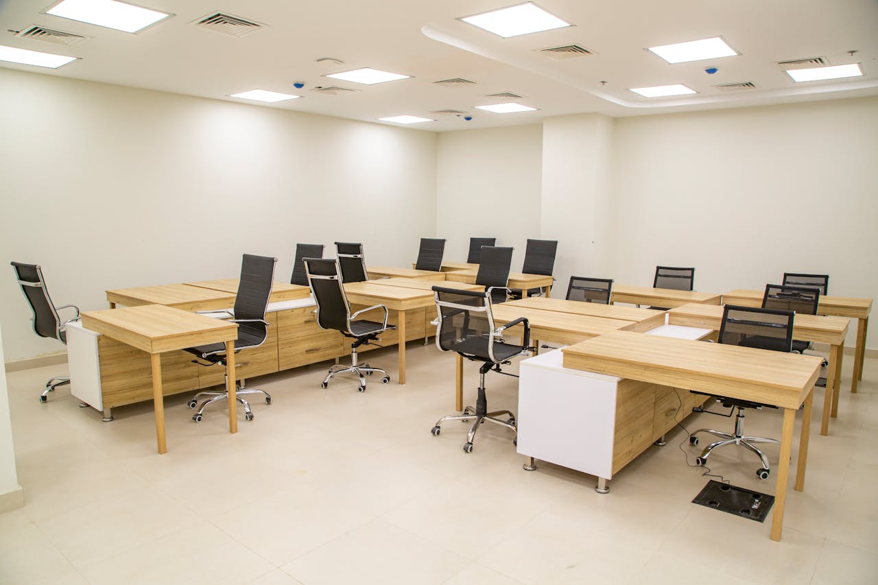 services-04 Spacious modern office with wooden desks and ergonomic chairs, ideal for team workspace.
